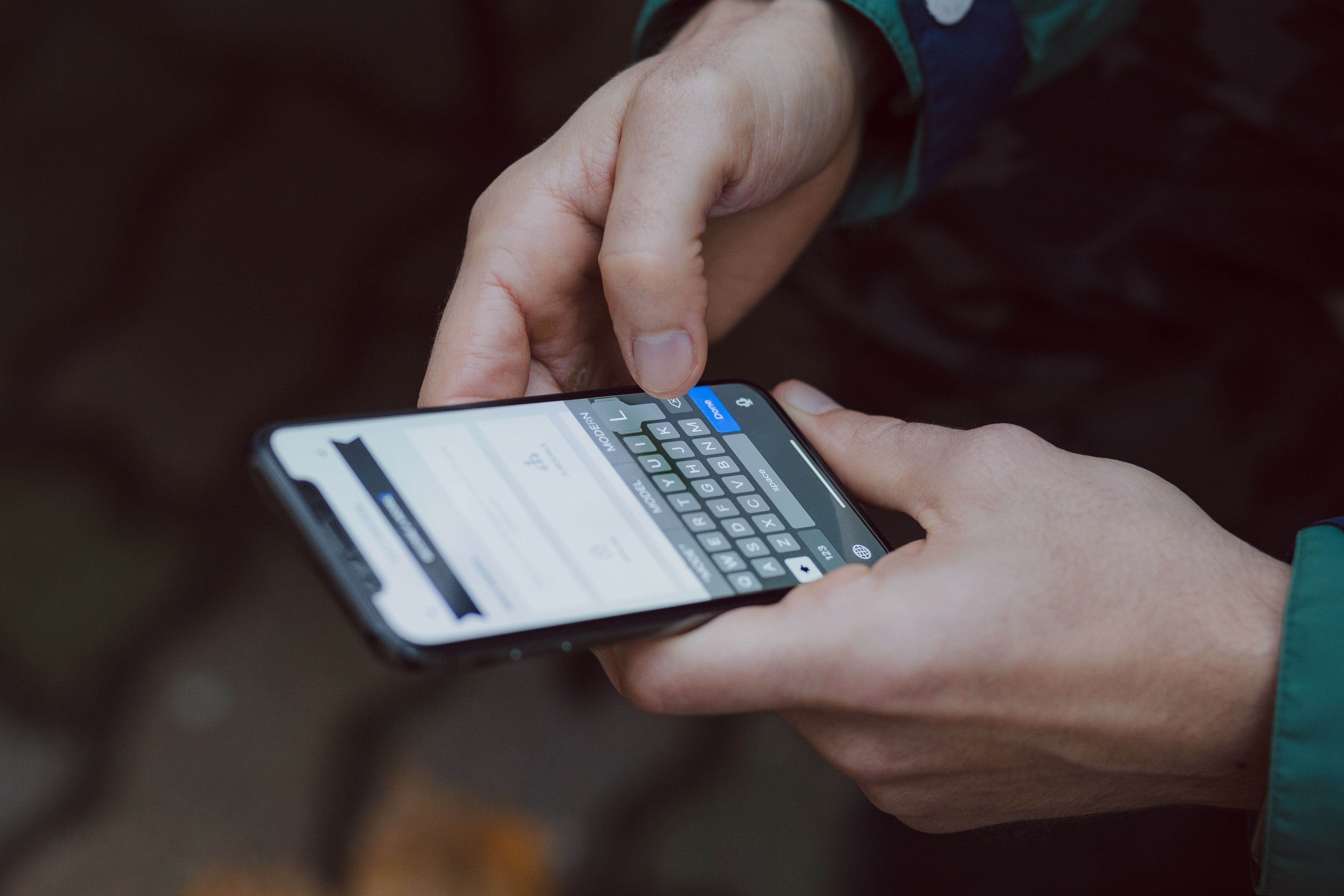 A person holding a mobile phone. © 2018 freestocks on Unsplash.